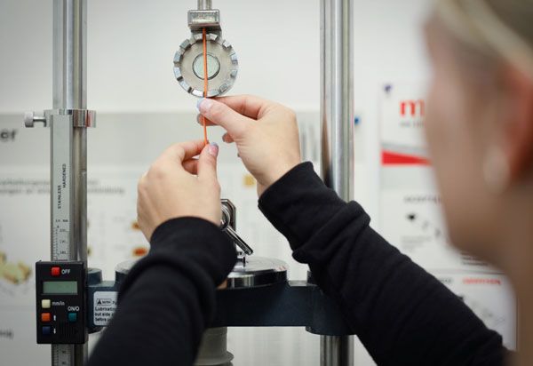 A person performing a precise measurement with a testing device.