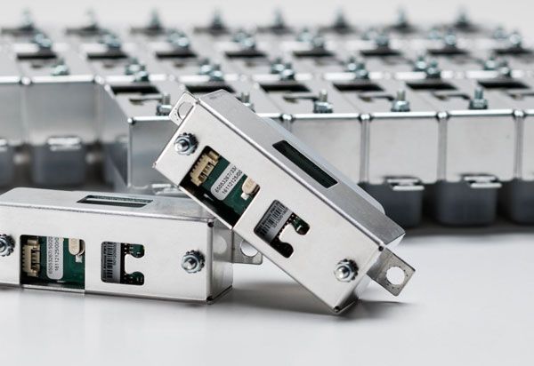 Several electronic modules made of metal with labels.